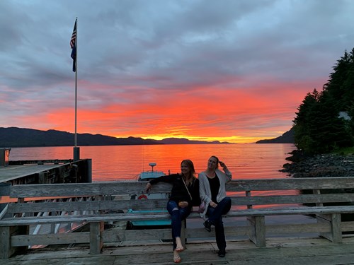 Two women guests enjoying a beautiful Southeast Alaska sunset from Waterfall Resort, an all-inclusive fishing lodge.